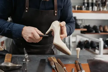 Técnico trocando salto de um sapato em uma oficina de sapatos.